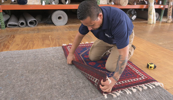 Professional worker installing rug pads