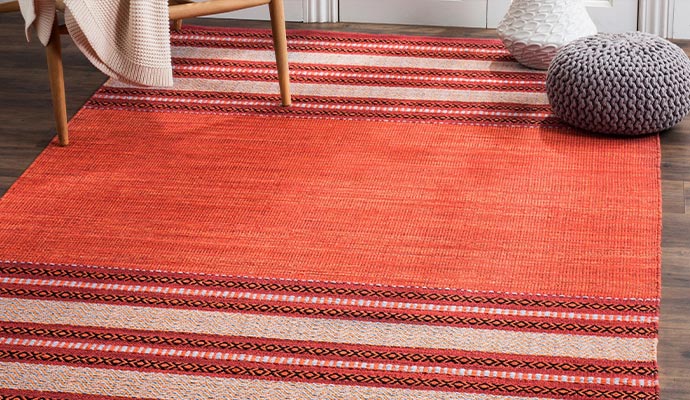 A flat-weave area rug on a wood floor