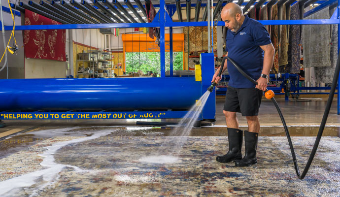 An expert cleaning a custom rug using professional equipment