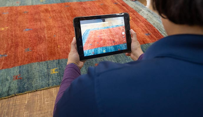 Technician inspecting a rug using a tablet at home