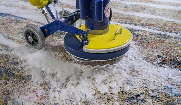 Deep cleaning an area rug using a rotary shampoo scrubber machine