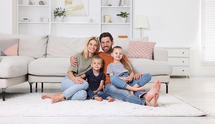 Family members sitting on white rug