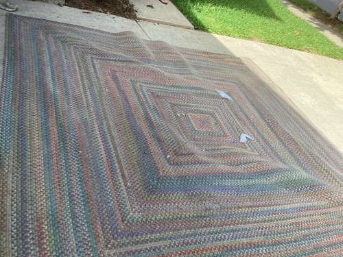 Professional braided area rug deep cleaning and flattening service correcting severe fiber buckling