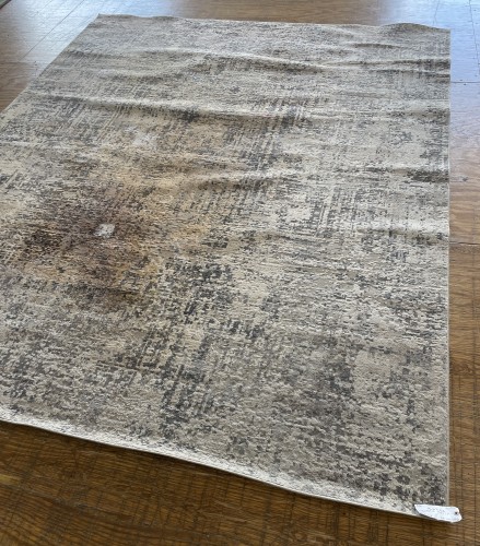 A large light grey and cream distressed abstract area rug, fully deep-cleaned and pile-restored to eliminate traffic matting on a workshop floor.