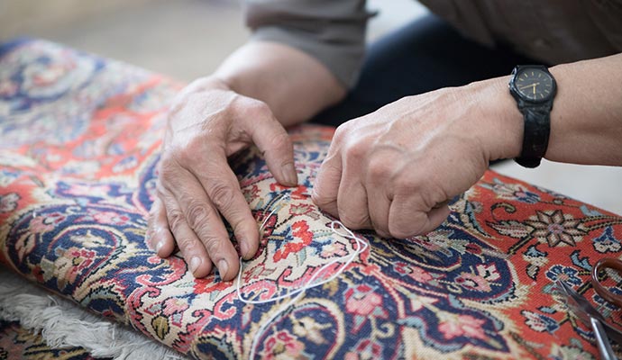 Professional worker repairing rug