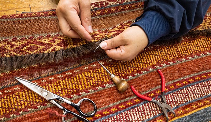worker repairing rug