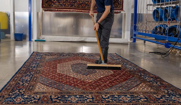 Worker cleaning Karastan rug.