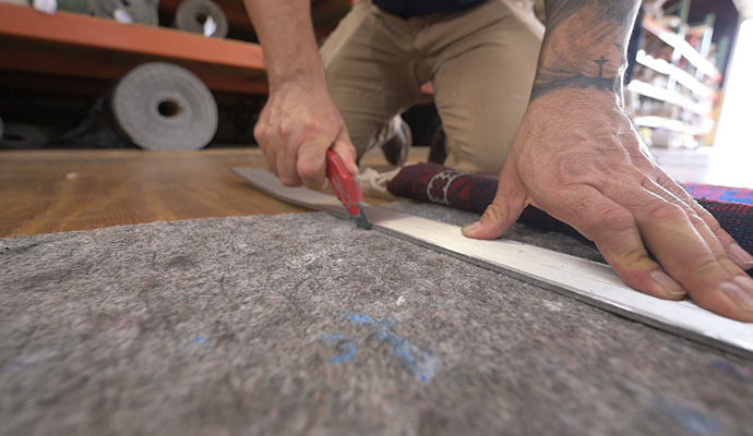 Worker cutting rug pads