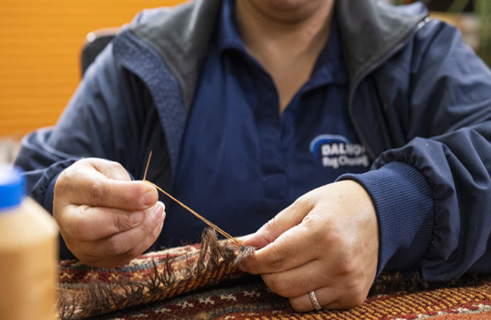 Repaired damaged rug edge.