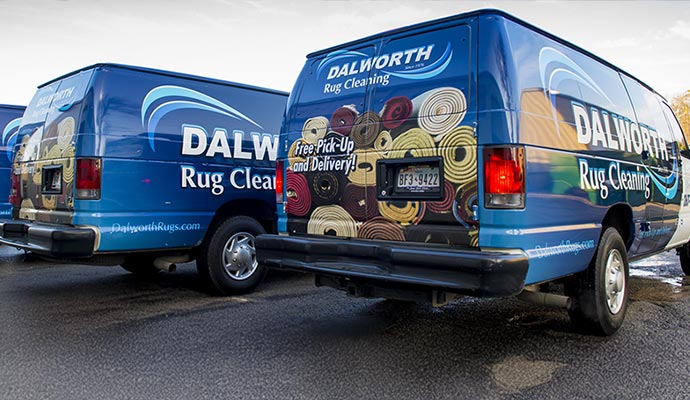 A row of Dalworth Rug Cleaning service vans providing free pickup and delivery throughout the Dallas-Fort Worth area.