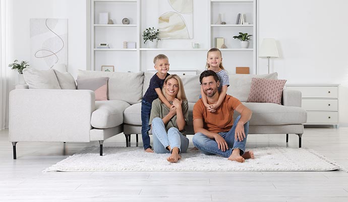 Happy family sitting on a fresh cleaned rug
