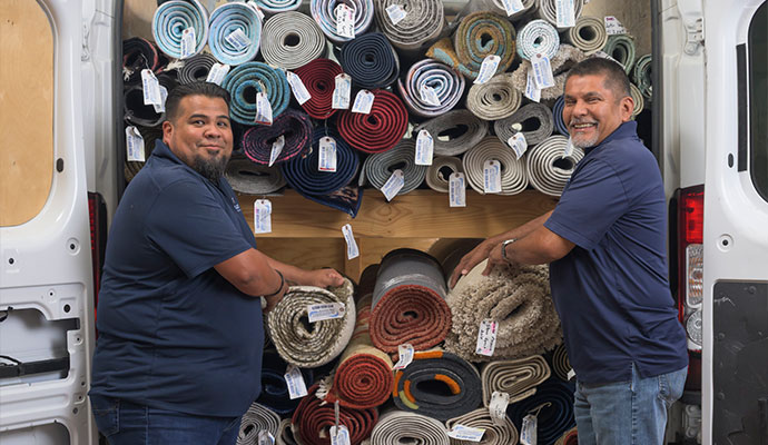 Two experts standing with a loaded rug truck, ready for professional rug delivery