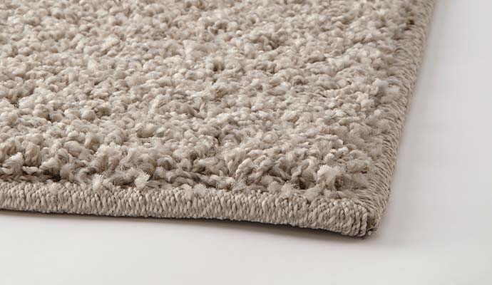 Rug edges being serged to prevent unraveling