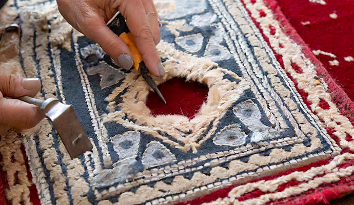 Expert repairing a hole in a rug