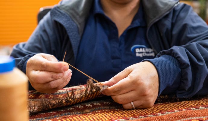 Professional worker repairing rug