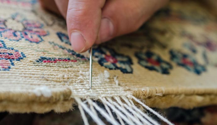 Professional worker repairing rug