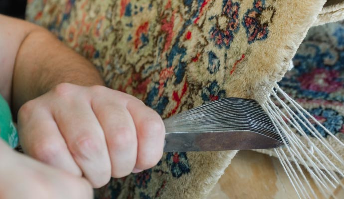Person patching a rug using equipment