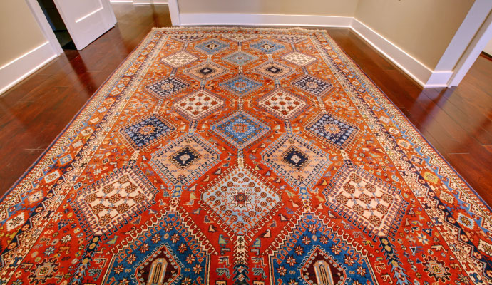 Red patterned antique rug on a wooden floor
