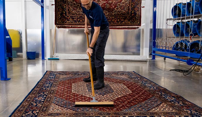 worker cleaning rug